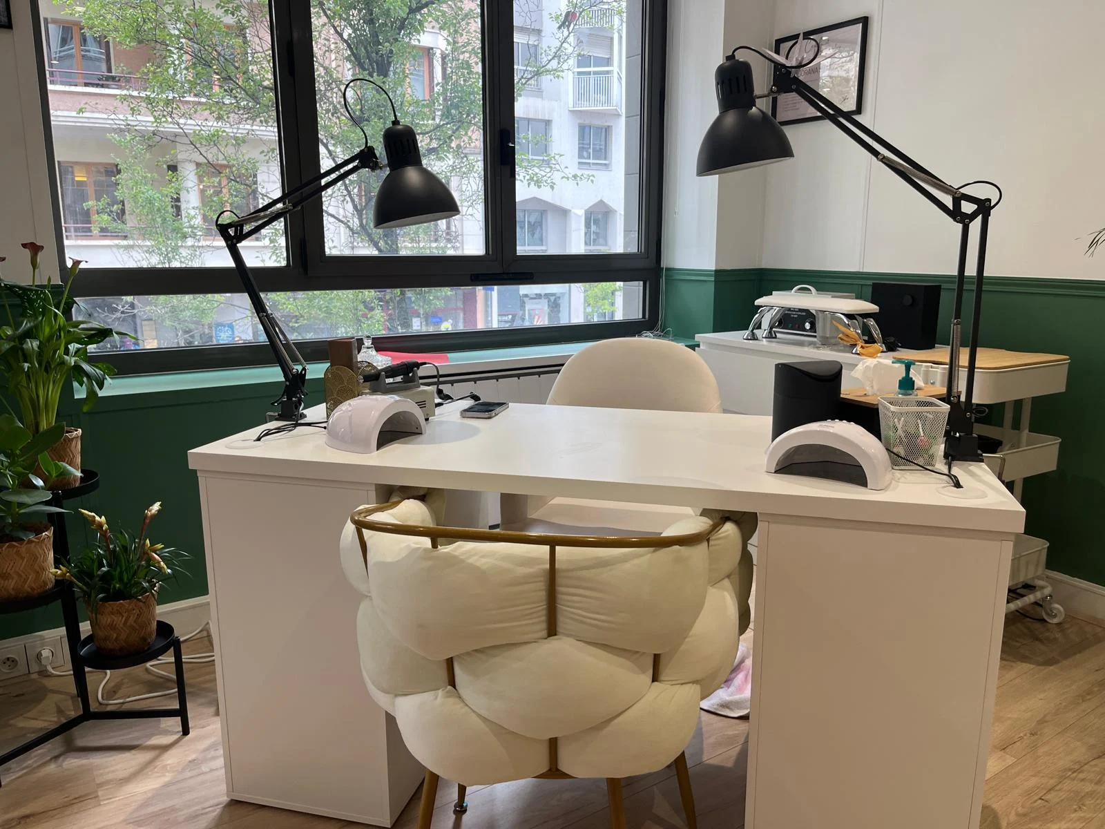 Poste manucure avec ses lampes noires et un fauteuil tressé crème